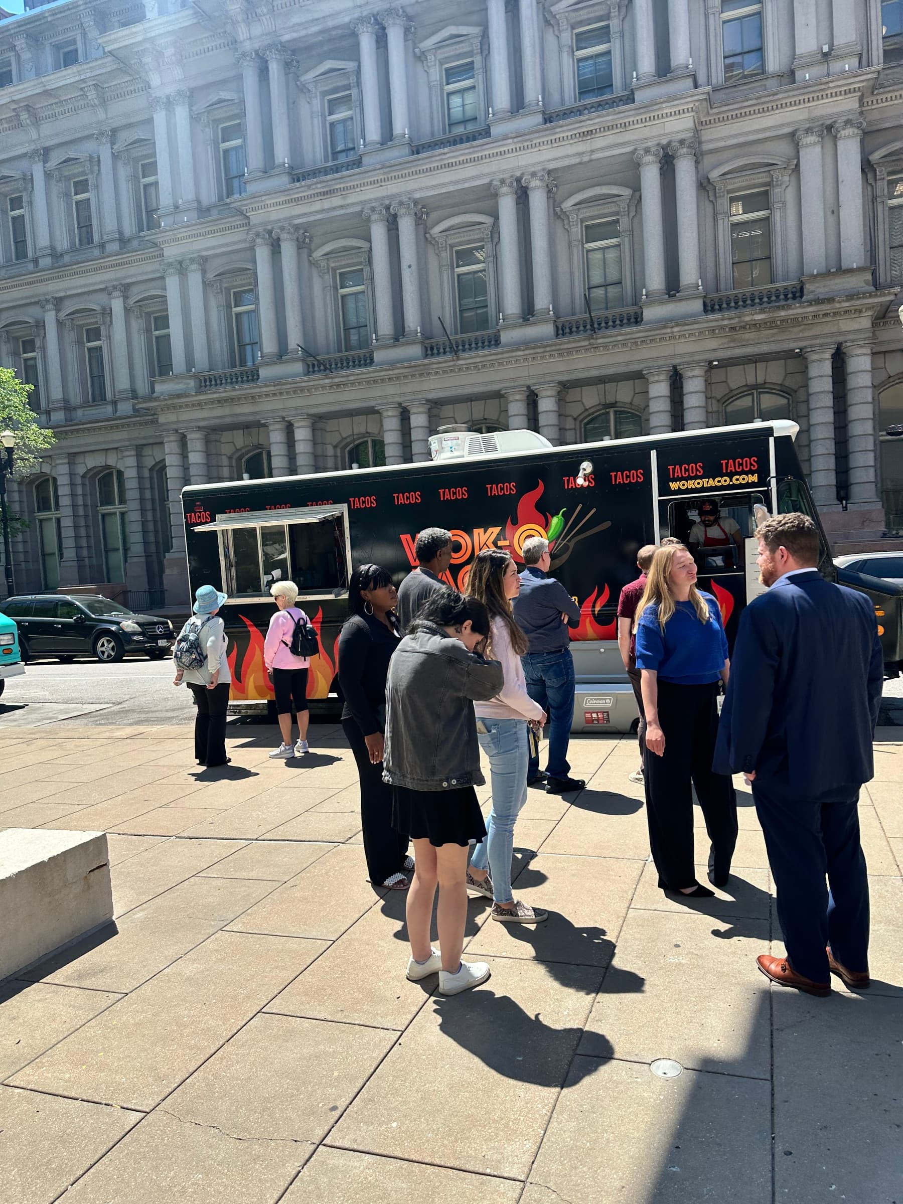 Guests lined up at the truck's service window in front of a historic stone building